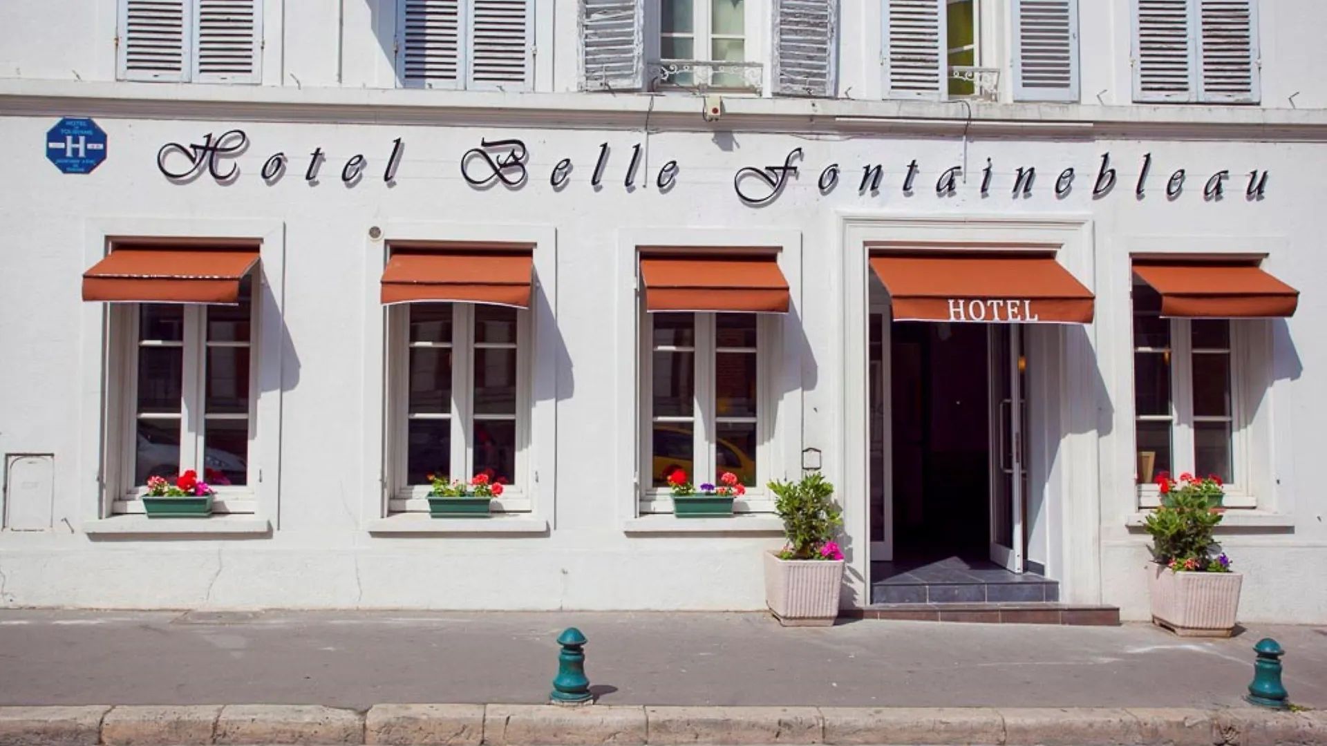 Façade de l’Hôtel Belle Fontainebleau avec ses stores rouges
