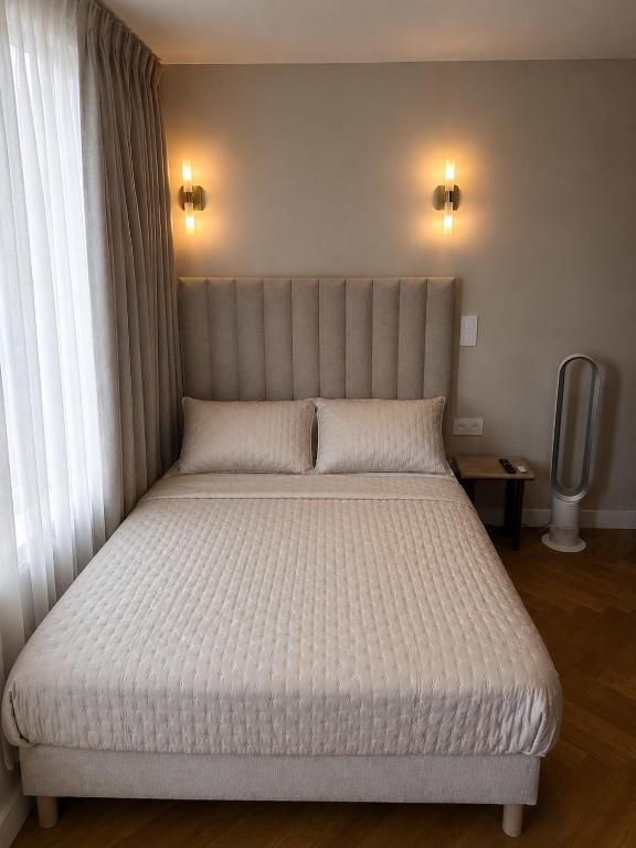 Chambre double avec tête de lit en tissu et parquet